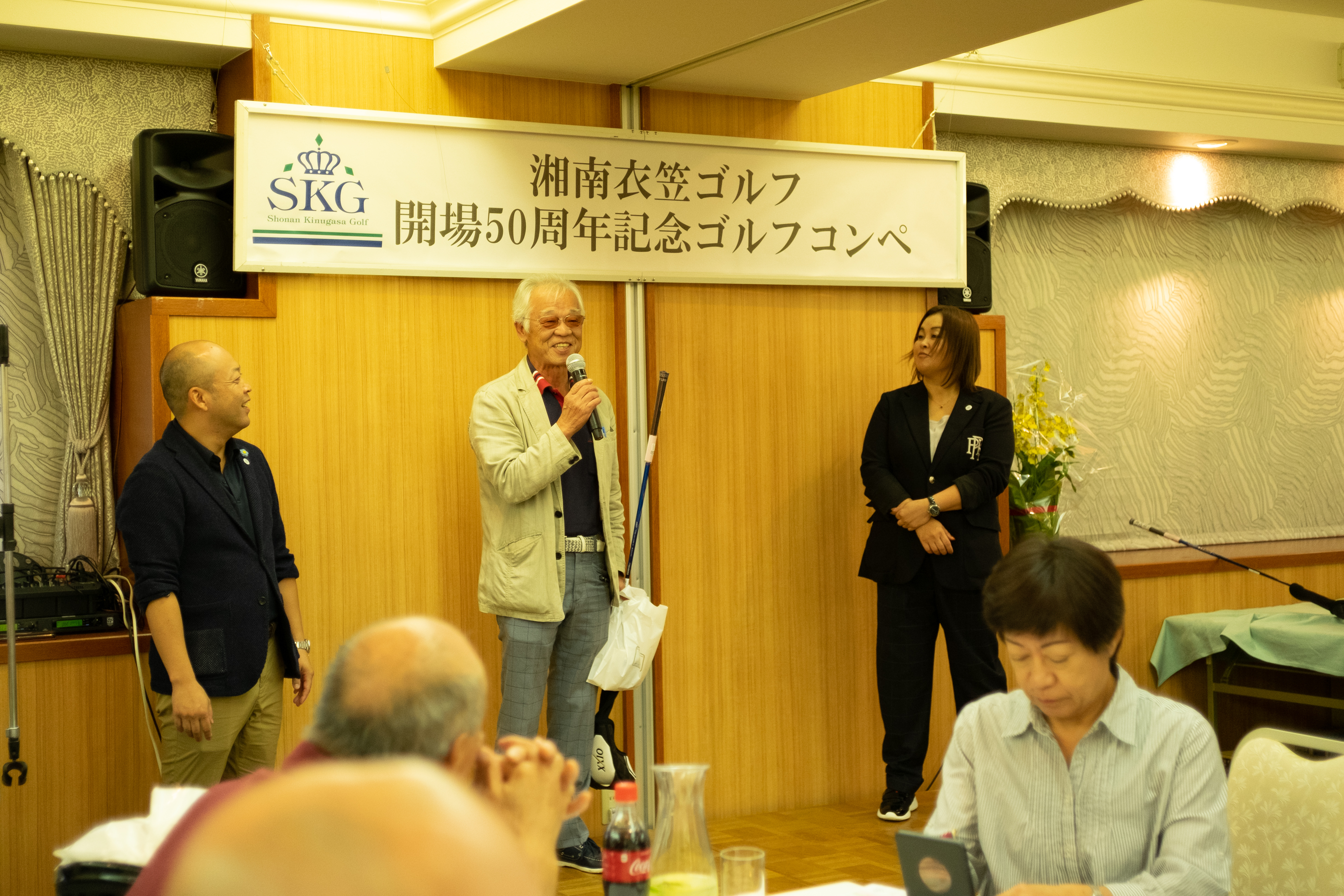 ゴルフコンペで表彰される男性